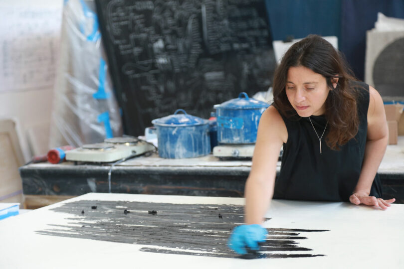 Artist drawing with black oil stick