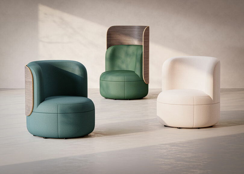 Three modern, rounded lounge chairs—two in green tones with wood panel backs and one in light beige—are arranged on a sunlit, minimalist floor.