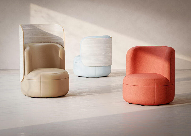Three modern, upholstered chairs in beige, light blue, and coral, each with curved backs and minimalistic design, arranged in a bright, sunlit room with a neutral background.